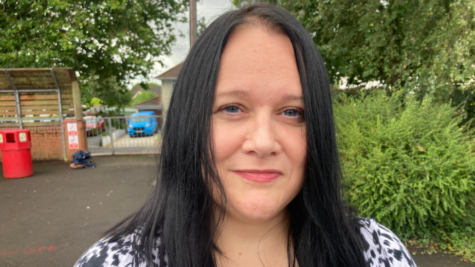 A woman standing in a car park