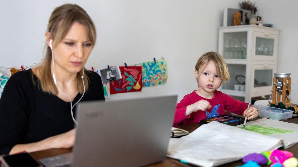 A photographer's son paints while his mother works and attends a digital conference at home in Zehlendorf district during the second wave of the coronavirus pandemic on 18 February 2021 in Berlin, Germany