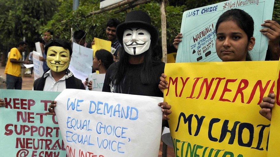 Indian activists wear masks as they hold placards during a demonstration supporting 'net neutrality' in Bangalore