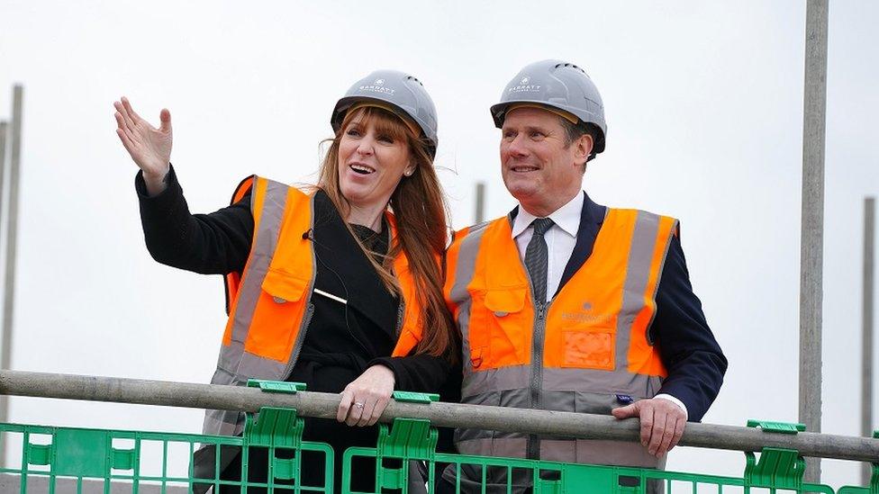 Labour leader Sir Keir Starmer and deputy leader Angela Rayner during a visit to a housing development in South Ribble in Lancashire. The pair are seen on a scaffold wearing hard hats and high vis jackets.