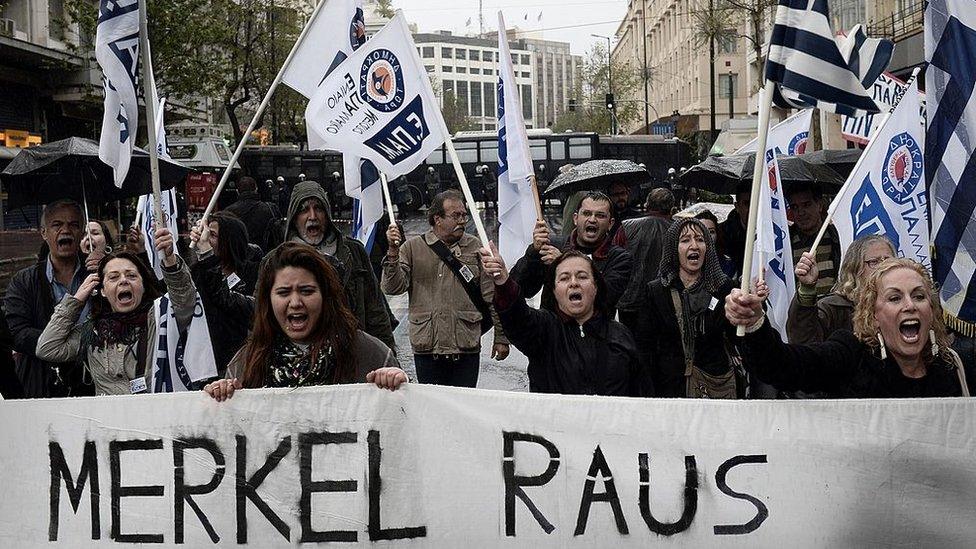 People demonstrate by a police blockade during a demonstration against the visit of the German Chancellor Angela Merkel in Athens on April 11, 2014