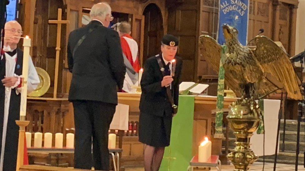 Candles being lit at the front of the church