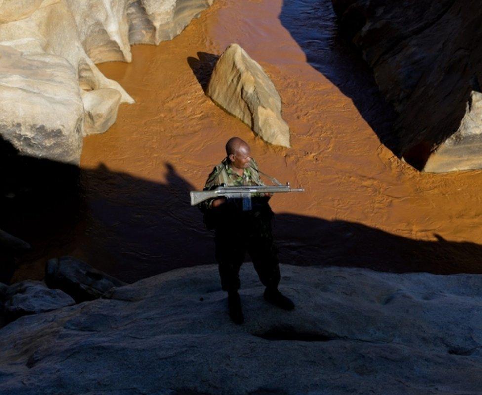 A wildlife ranger stand guard as local tourists (not visible), visit to see the Ewaso Nyiro river, during an early morning game drive through the Shaba National Reserve which is a protected area, in Isiolo, northern part of Kenya, 10 April 2016. The Government of Kenya, through its Ministry of Tourism, has created a project called "Tembea Tujenge Kenya" which is a Swahili name meaning (Walk We Build Kenya), as a way to reduce its dependency on foreign tourists by promoting Kenyan tourism and encouraging people living in Kenya, East and West Africa to sample the local eco, cultural, sports and conference tourist destinations in Kenya.