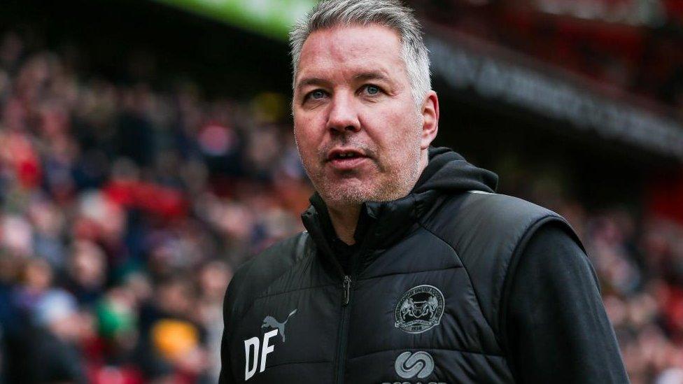 Darren Ferguson at a match with crowd behind him