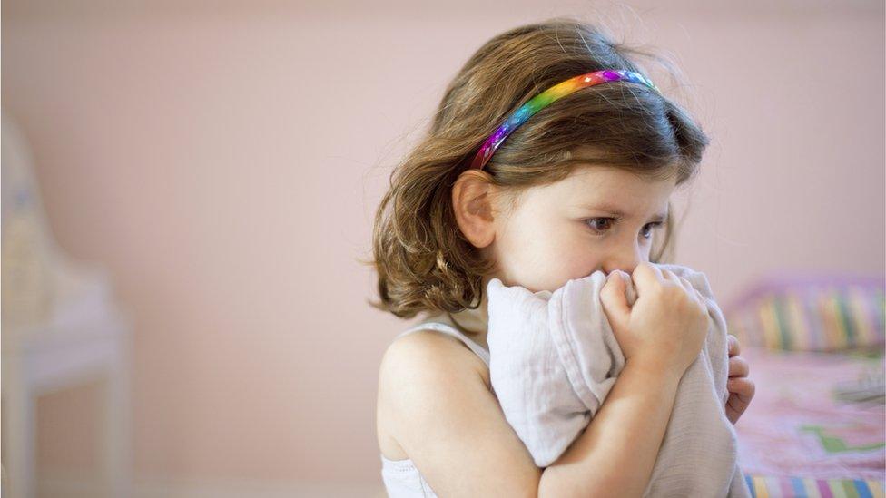 Young girl holding a cuddly toy