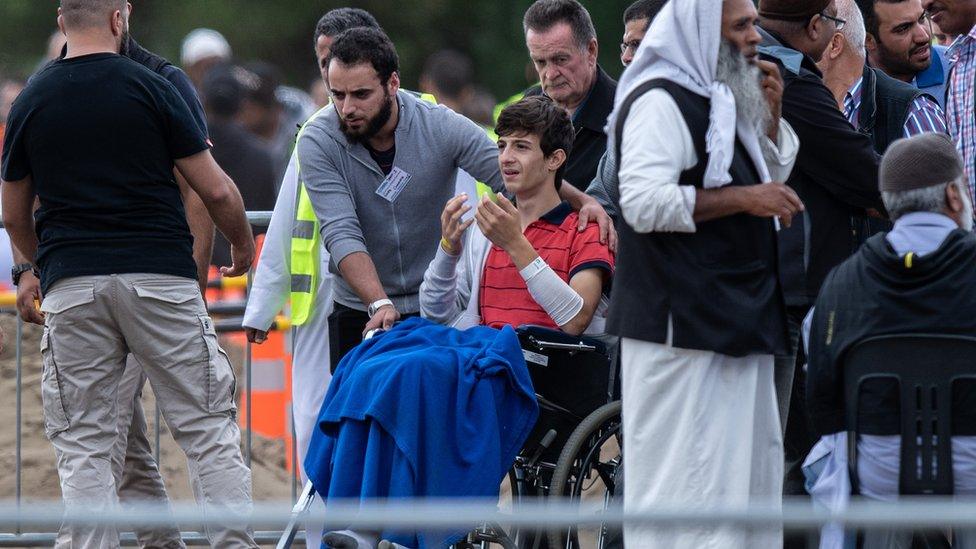 Zaid Mustafa in a wheelchair at the funeral for his father and brother