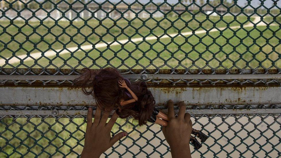 From the Mexican side of the Gateway International Bridge, Sol, an 8-year-old girl from Honduras, looks over the United States side of the Rio Grande