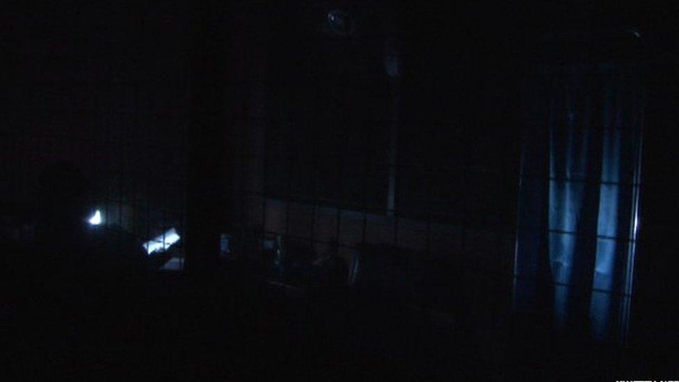 A health worker uses a mobile phone at Accra's Kaneshie polyclinic during a power cut