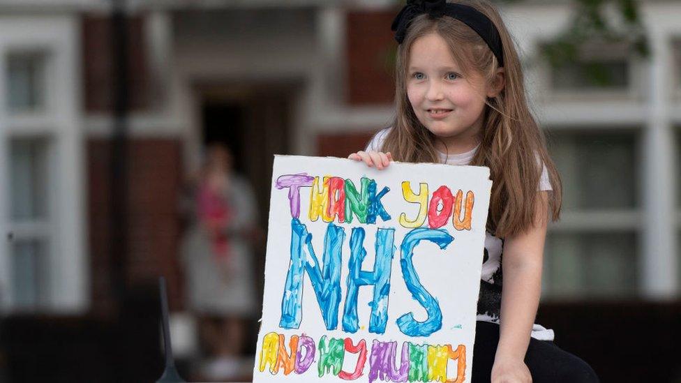 Girl with sign saying Thank you NHS and my mummy
