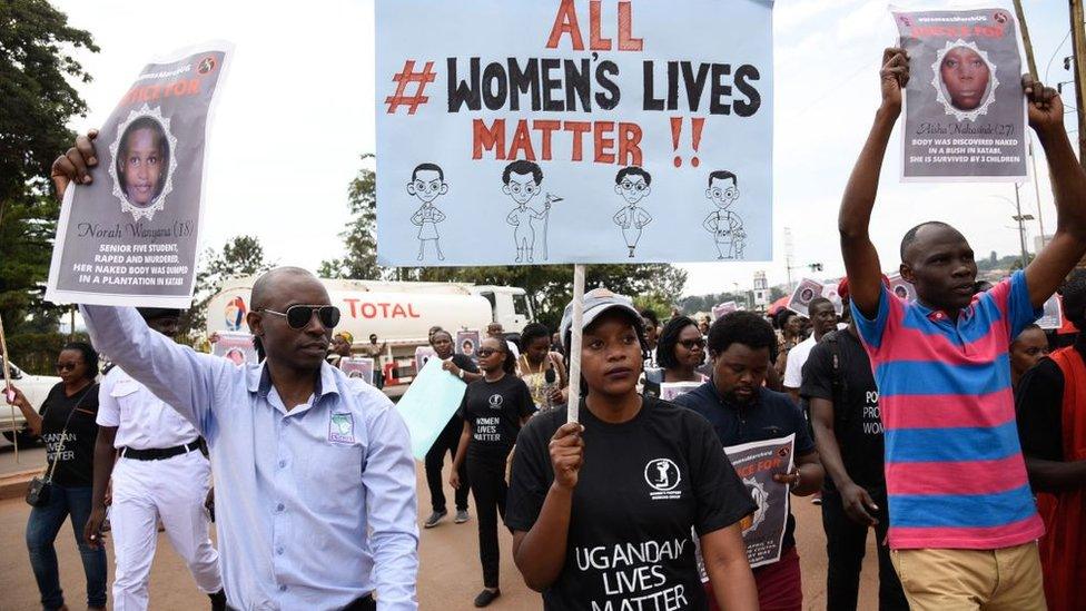 Protesters hold banners during the women's march demanding police action to stop a spate of kidnapings and murders of women in Kampala, Uganda, on June 30, 2018