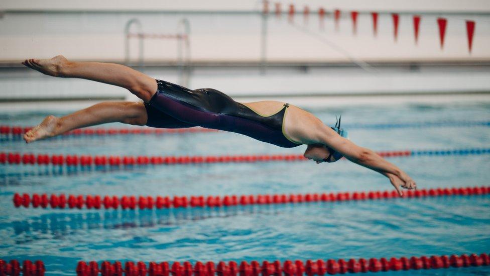 Woman diving into a swimming pool - stock photo