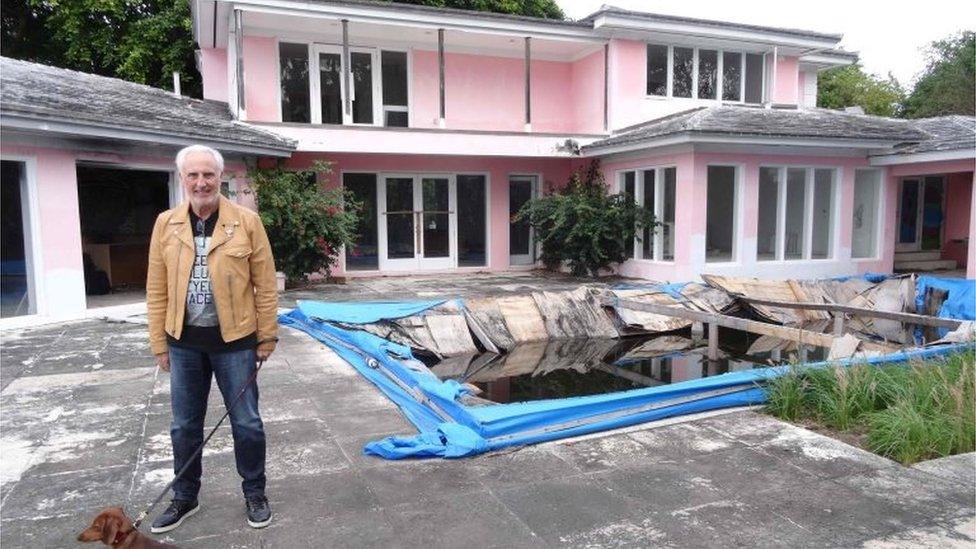 Christian de Berdouare stands with his dog by a pool of a house that used to belong to notorious Colombian drug lord Pablo Escobar on January 13, 2016, in Miami Beach, FL.