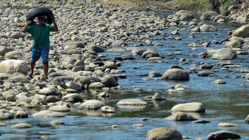 A man crosses from Venezuela through "trochas" - illegal trails