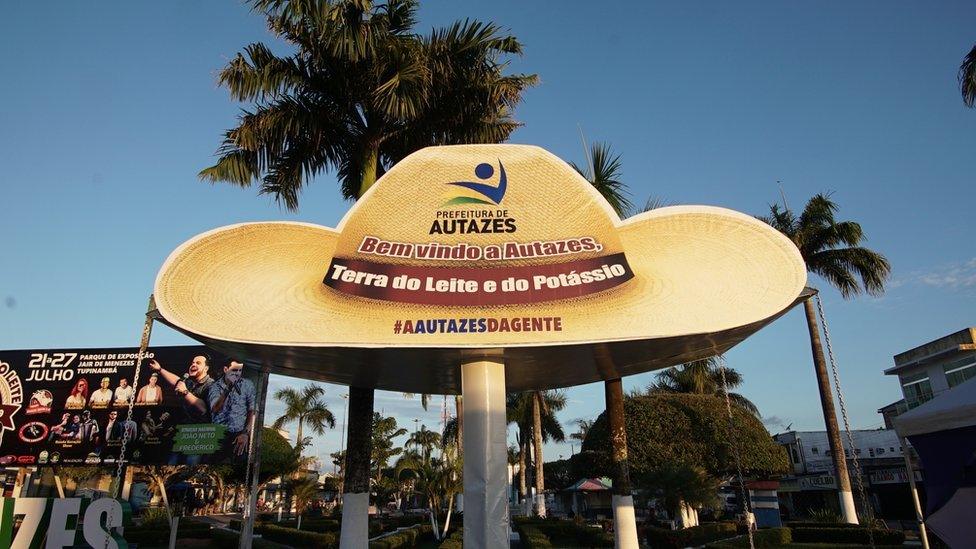 Photo of a sign reading "Welcome to Autazes, Land of Milk and Potassium"