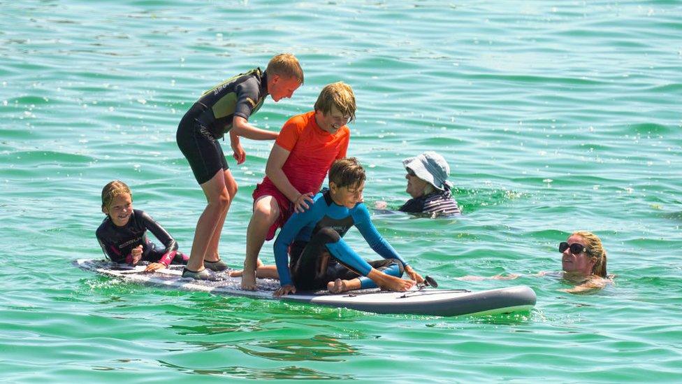 Paddle boarders were among those who gathered to enjoy the sun on Gyllyngvase Beach on July 17, 2021 in Falmouth,