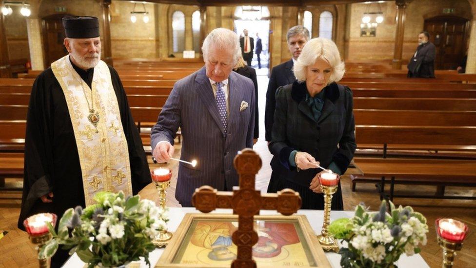 The Prince of Wales and Duchess of Cornwall light candles during a visit to the Ukrainian Catholic Cathedral in London.