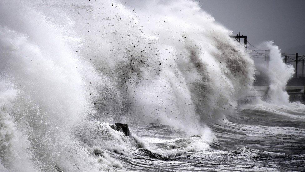 Waves crashing over a railway line in Scotland.