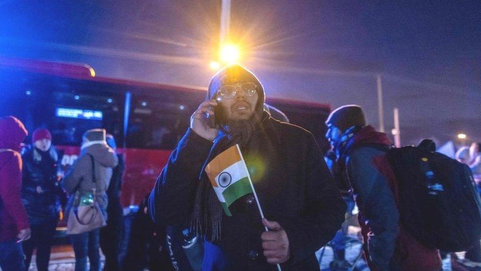 A man with an Indian flag waits for his friends upon his arrival from the Medyka pedestrian border crossing, in Przemsyl, eastern Poland on February 26, 2022, following the Russian invasion of Ukraine.