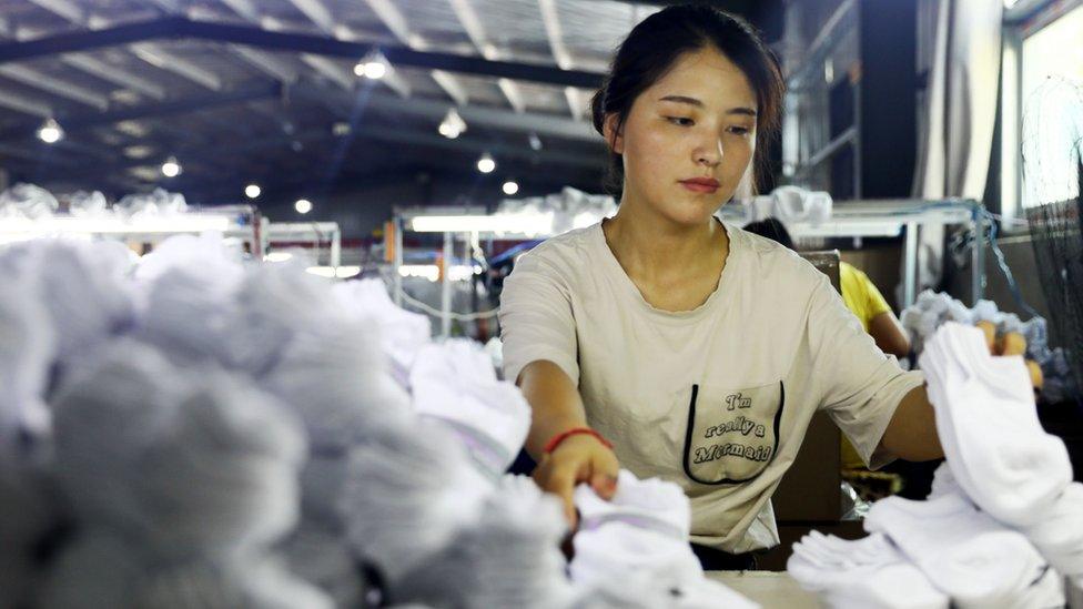 A woman works on socks that will be exported to the US at a factory in Huaibei in China's eastern Anhui province on August 7, 2018.