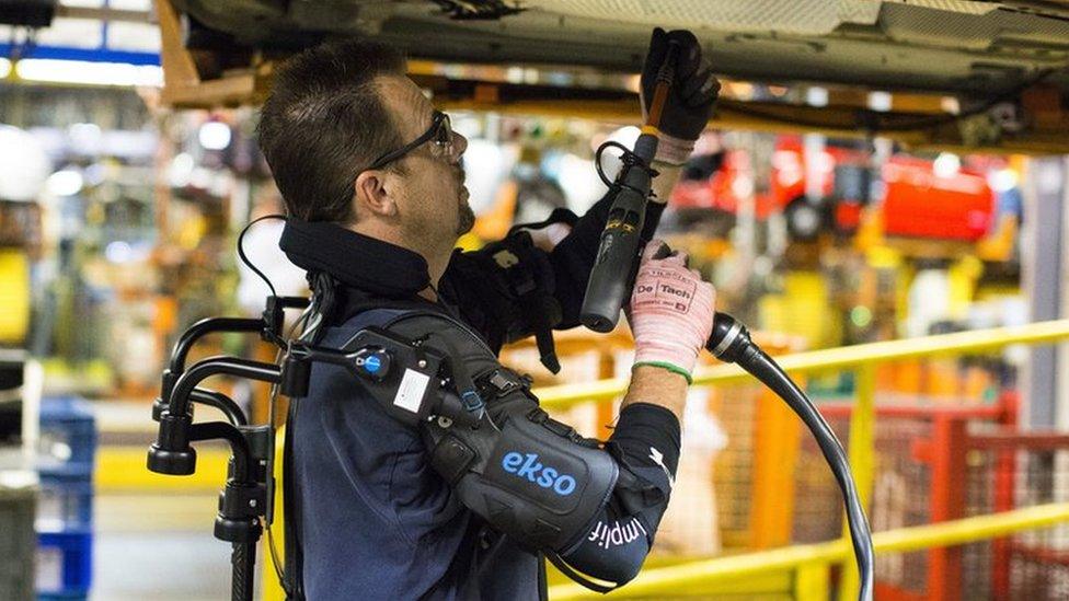 A car worker using a robotic suit