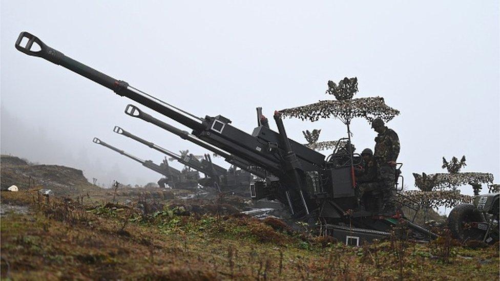 Indian Army soldiers are pictured on a Bofors gun positioned at Penga Teng Tso ahead of Tawang, near the Line of Actual Control (LAC), neighbouring China, in India's Arunachal Pradesh state on October 20, 2021.