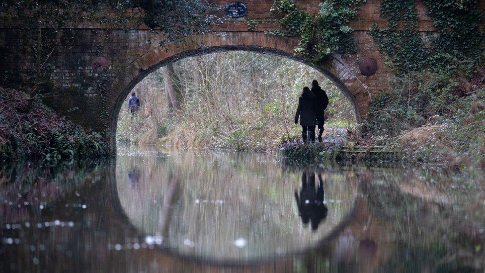 People walk along the Basingstoke canal, near Dogmersfield in Hampshire