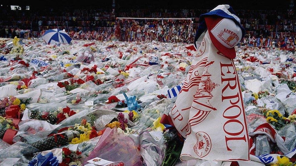 Flowers, scarves and hats laid in tribute to the Hillsborough victims cover the pitch at Anfield
