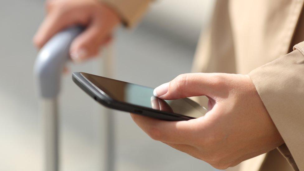 Business traveller checks mobile phone