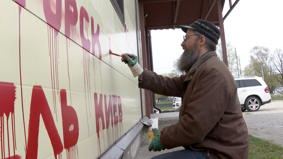 Image shows businessman painting