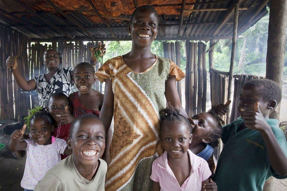 A mother and her children smile and make funny faces for the camera inside their home in the small town of Clay Ashland, Liberia. The town is where the UN Mission in Liberia (UNMIL) has built a new magistrates' building, one of its Quick Impact Projects, or QiPs, which refurbish or construct courthouses, police stations, and police barracks, to strengthen the rule of law in the country.