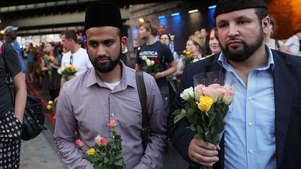 Men bring flowers to the vigil in Finsbury Park