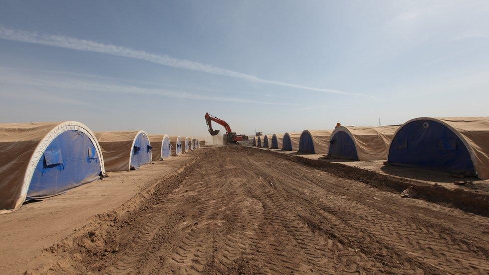 Workers prepare a tent camp west of the Kurdish regional capital Irbil, Iraq