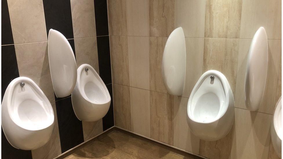 Three white urinals