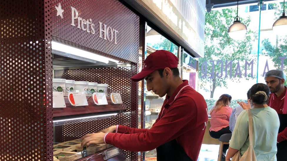 Worker fills shelves at Pret A Manger shop in Mumbai.