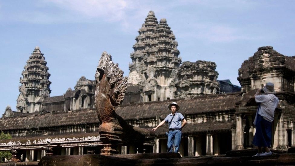 Tourists taking pictures at the Angkor Wat temple complex in Siem Reap province, Cambodia