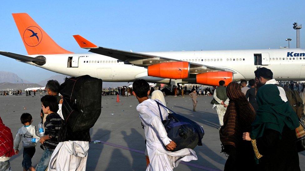 family in Afghanistan walking to plane