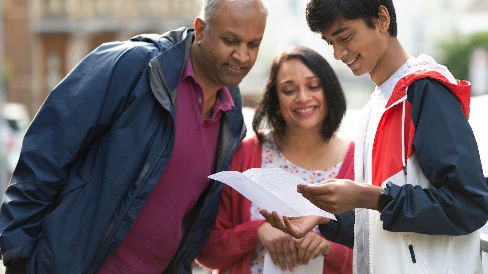 Milind Patel opens his GCSE results with his parents at Ffynone House School on August 12, 2021 in Swansea