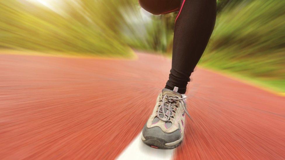Close-up of running legs on a road surface