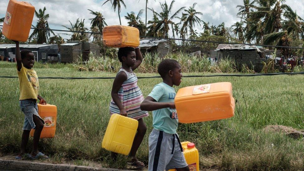 Children holding empty plastic containers in Mozamique