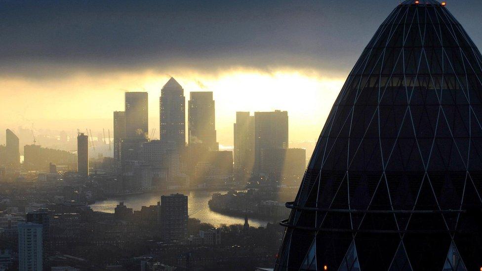 Canary Wharf seen at sunrise, behind the roof of The Gherkin