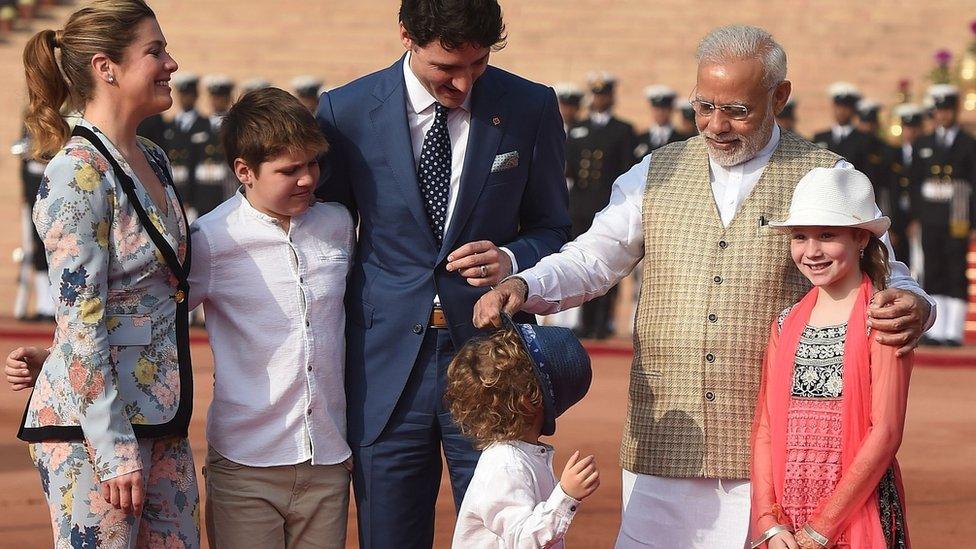 Narendra Modi putting Hadrien's hat in front of his face