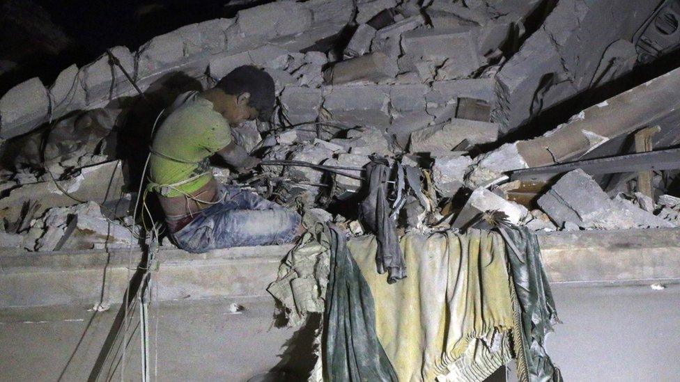 Syrian boy waits to be rescued from Qaterji, Aleppo