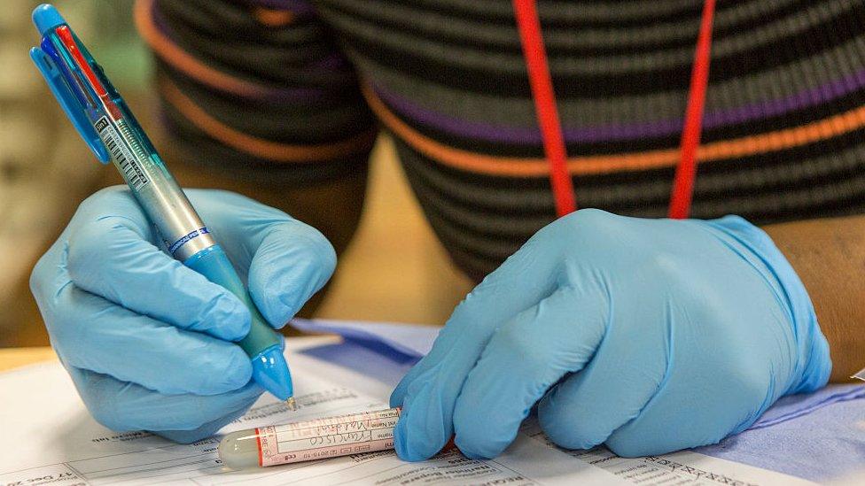 Health worker with sample tube