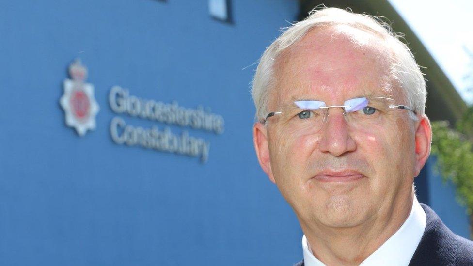 Chris Nelson looking at the camera while standing by a Gloucestershire Constabulary sign