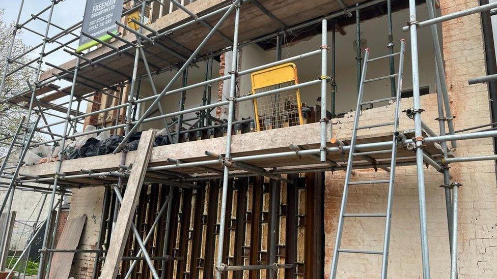 The scaffolding and covers on a house wall