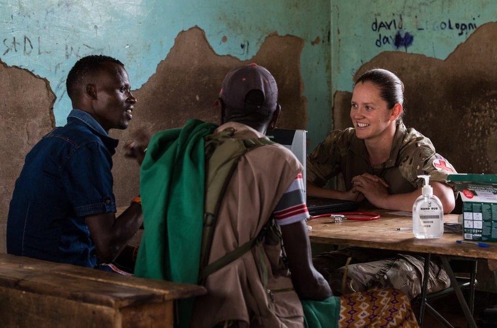 A soldier talking to two men