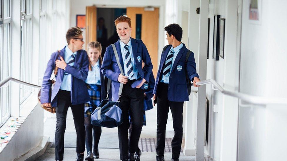 Teenagers walk in school uniform