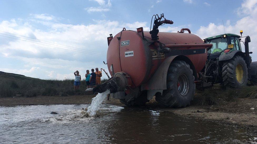 tanker refilling a watering hole