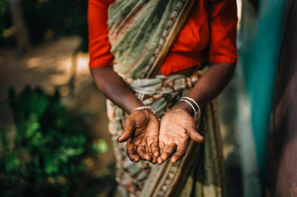 A tea plucker holds out her hands