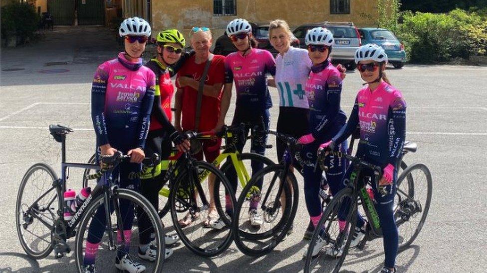 A group photo including five cyclists and their bikes